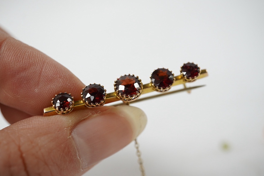 A 9ct gold, peridot and ruby cluster set ring (peridot loose), size P, together with an early 20th century 9ct gold and garnet set bar brooch and a pair of yellow metal and coral set drop earrings, gross weight 5,9 grams